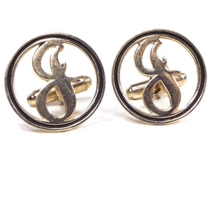 Front view of the Mid Century vintage initial cufflinks. They are round and gold tone in color with a black painted edge. There is a cut out letter J in the middle.
