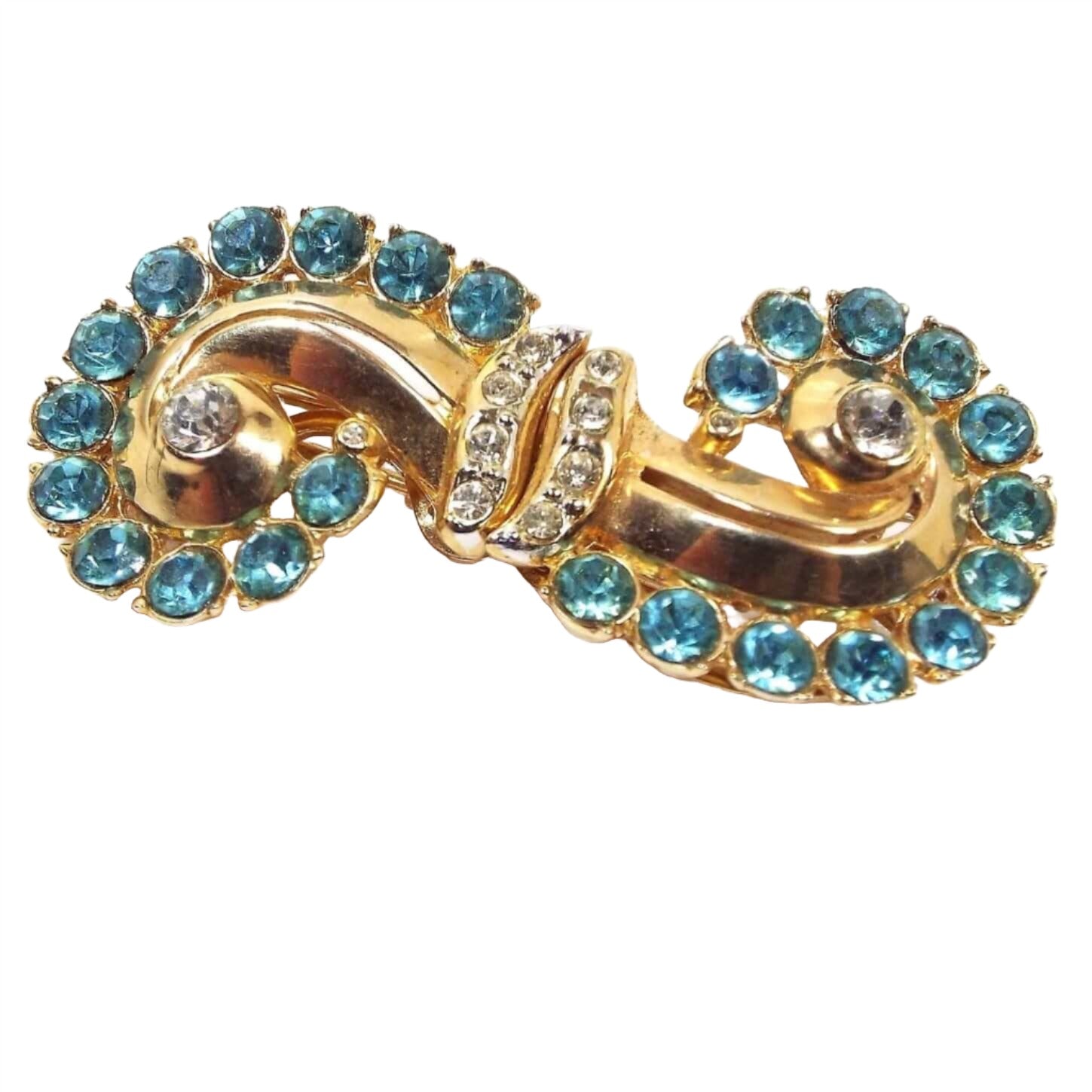 Front view of the 1930's Art Deco vintage Coro Duette Brooch pin fur clip combo. The metal is gold tone in color. Each side is curved around and back inwards with each side curving in a different direction for an S like shape. The outer edge has round blue rhinestones with a clear rhinestone in the middle. There are two bands of clear rhinestones going across the middle of the brooch. The stones are affixed to the brooch with adhesive and small bump style prongs.