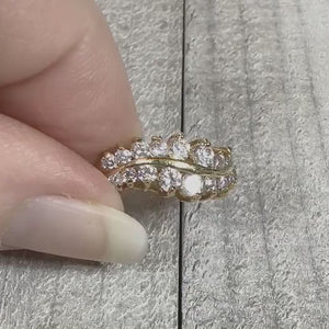 Video showing the sparkle on the retro vintage cubic zirconia ring. The metal is gold tone plated in color. There are two curvy rows of round CZ stones.