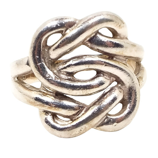 Front view of the retro vintage sterling Celtic knot ring. The silver is very slightly darkened in color from age. The top of the ring has an open Celtic knot design with rounded bands of metal. 