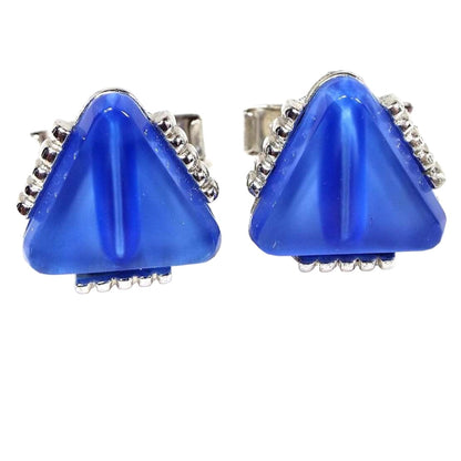Front view of the Mid Century vintage triangle cufflinks. The metal is silver tone in color. The fronts have blue glass rounded triangles. there is a line of silver tone dots on each side of the triangle. 