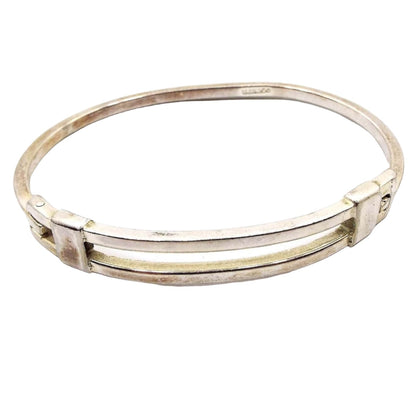 Front view of the Mexican retro vintage bangle bracelet. It is silver tone in color with a hinge on the front side. 