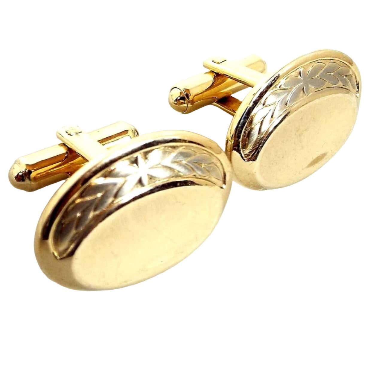 Angled front view of the retro vintage Hickok cufflinks. They are oval in shape and mostly gold tone in color. There is a silver tone leaf design around the top edge.