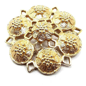 Front view of the Mid Century Vintage Sarah Coventry floral brooch pin. The metal is gold tone in color. The brooch has a filigree star shape with six round flower shapes around the outside of the brooch and a flower shape in the middle.