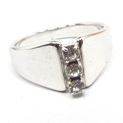 Front view of the retro vintage angled rhinestone ring. The metal is silver tone in color. There is a vertical row of three round clear prong set rhinestones on the frontl. The sides are flared and angled up the the rhinestones.
