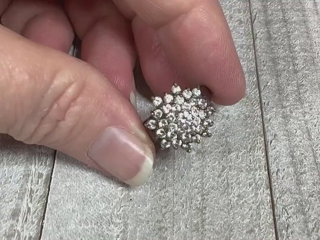 Video of the retro vintage sterling silver cubic zirconia cocktail ring. There is a large cluster of small round clear CZ stones at the top. The video is showing how they sparkle.