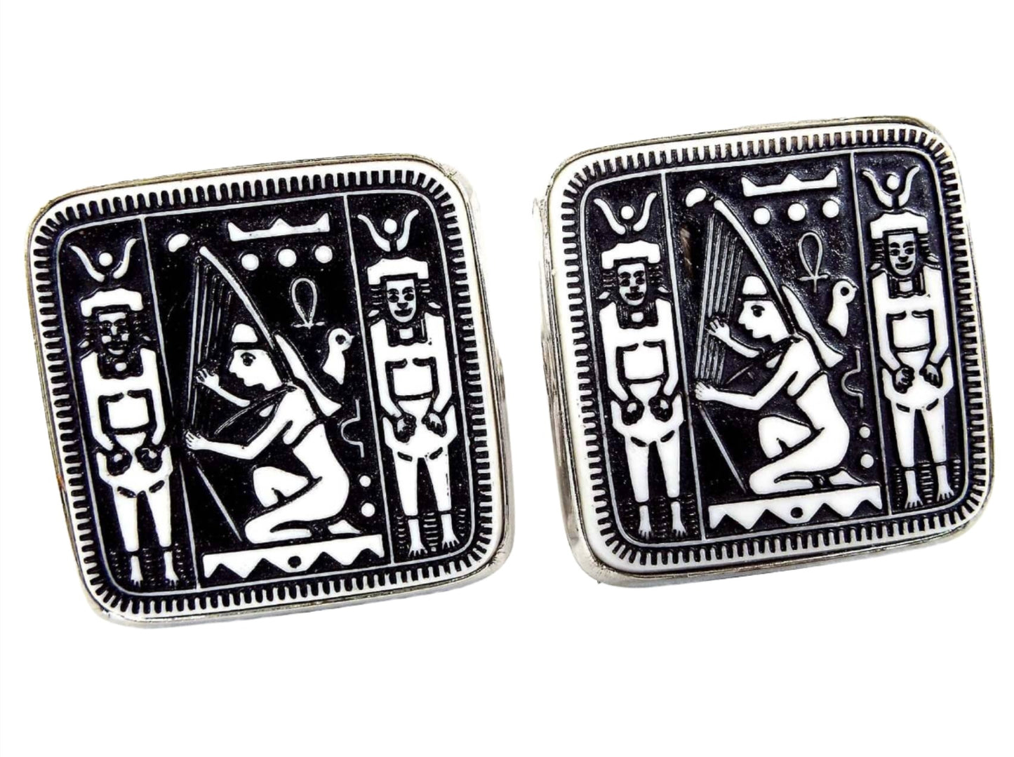 Front view of the Mid Century vintage Dante Egyptian Revival cufflnks. They are rounded square in shape with silver tone color metal. The front cabs are black with a white hieroglyphic style design. 