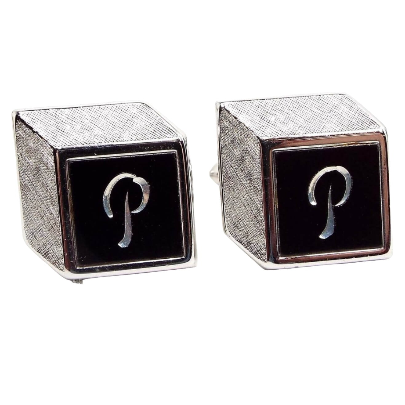 Front view of the retro vintage Swank initial cufflinks. They are silver tone in color with black painted fronts that have the letter P engraved on them. The design is meant to make them look like 3D cubes from the front though they are flat. The top and side angled edge are textured silver tone in color.