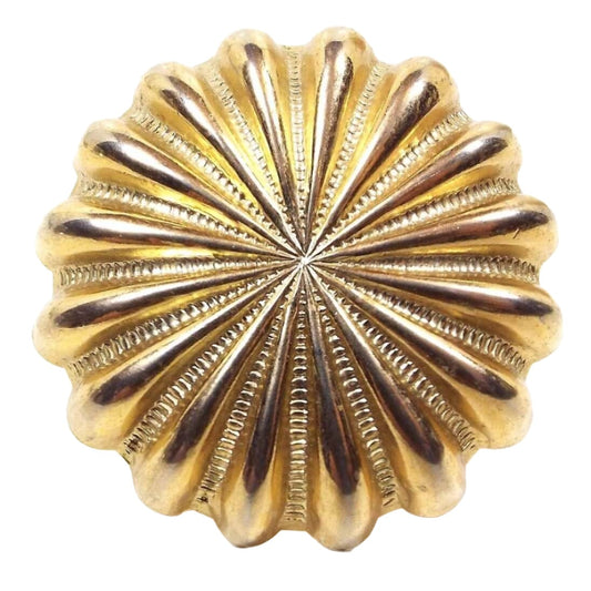 Front view of the retro vintage scarf slide ring. It has a scalloped starburst style design and is gold tone in color.