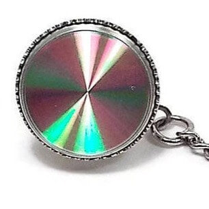 Enlarged front view of the retro vintage holographic tie tack. The metal is silver tone in color. It's round with a plastic holographic disc front.