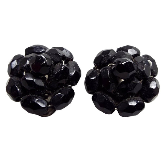 Front view of the Mid Century vintage glass cluster beaded clip on earrings. The beads are faceted oval and black in color. 