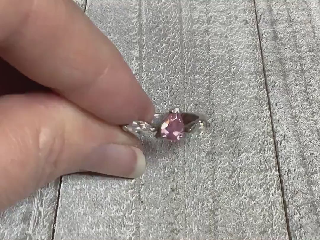 Video showing the sparkle on the cubic zirconia stones on the sterling silver retro vintage ring. There is a teardrop shaped pink CZ in the middle and clear marquis shaped CZ stones on each side of that. 