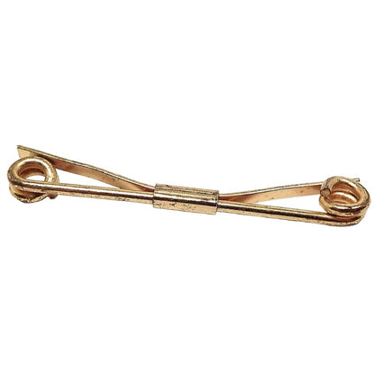 Angled front view of the gold tone Mid Century 1940'sl spiral end collar clip. The back is angled, There is scuff scratching and darkened areas on the spiral ends.