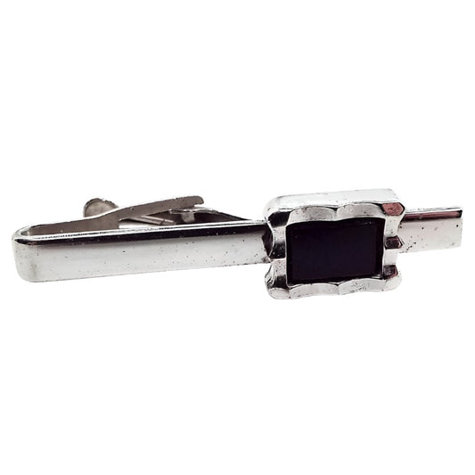 Front view of the retro vintage Foster tie clip. The metal is silver tone in color. There is a black rectangle at the end.