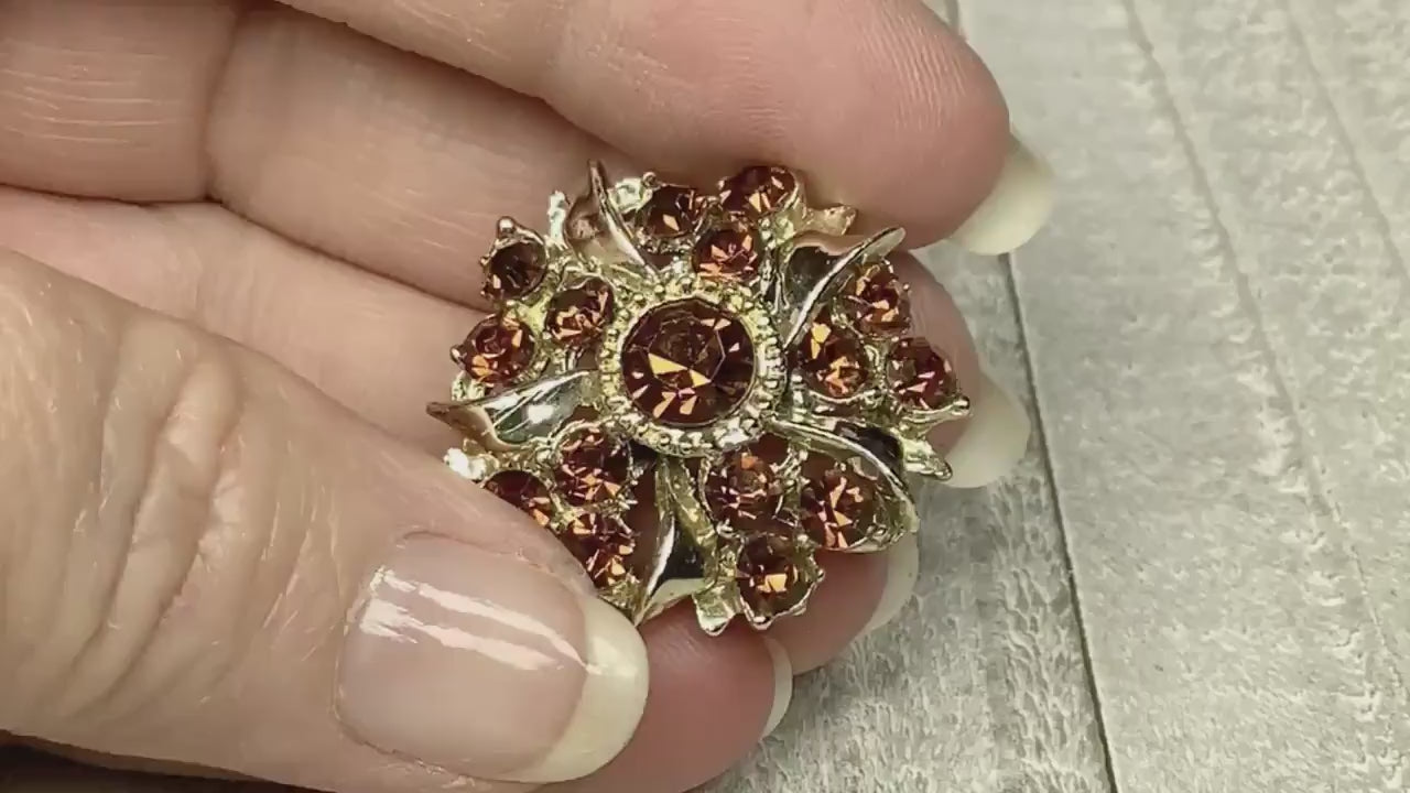 Video of the Mid Century vintage rhinestone brooch. The metal is gold tone color and it has brown rhinestones. The video is showing how they sparkle.