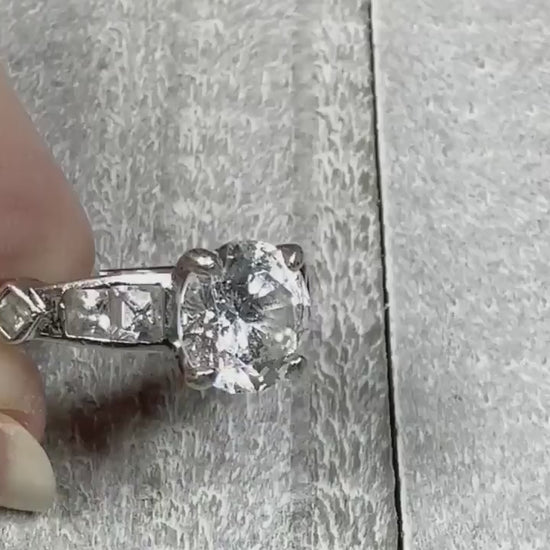 Video of the retro vintage sterling silver cubic zirconia ring. There is a round CZ at the top with two square CZ stones on each side. On the sides of the ring are single square rhinestones turned so they look like a diamond shape. The video is showing how the sparkly the cubic zirconia stones are.