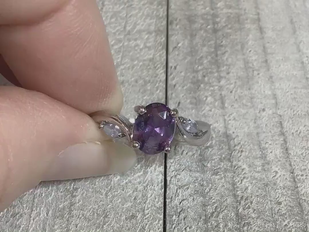 Video of the retro vintage rhinestone cocktail ring. The metal is silver tone in color. There is an oval purple rhinestone at the top with a marquis shaped clear rhinestone on each side of it. The video is showing how the rhinestones sparkle.