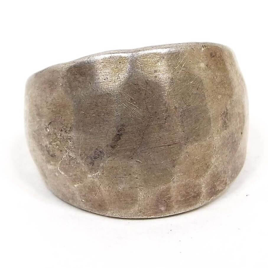 Front view of the wide retro vintage sterling silver hammered band ring. The sterling is darkened from age. It has a hammered design around the top of the band. 