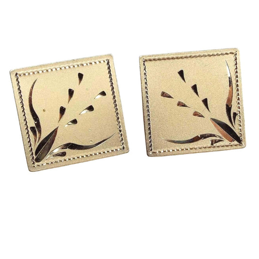 Front view of the Mid Century vintage Anson cufflinks with diamond cut etched design. The are matte gold tone in color and square in shape. There is a cut leaf style design going diagonally inward. 