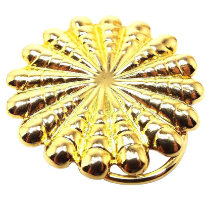 Front view of the retro vintage scarf clip. It is gold tone in color and has a scalloped round style starburst design.