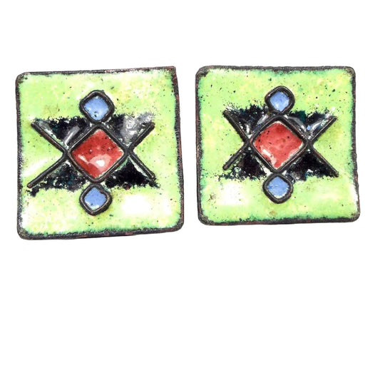 Front view of the retro vintage enameled cufflinks. The are curved squares with a red, black, and blue diamond like pattern on a bright green enamel background.