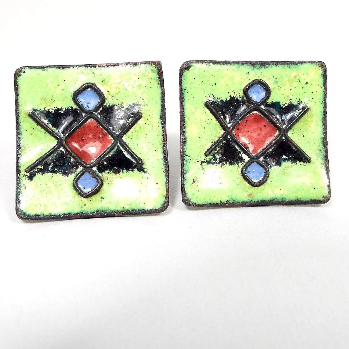 Front view of the retro vintage enameled cufflinks. The are curved squares with a red, black, and blue diamond like pattern on a bright green enamel background.