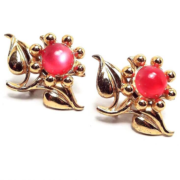 Front view of the Mid Century vintage vermeil floral earrings. The vermeil is gold plated over sterling for a rich gold color. They are shaped like flowers and have round domed glass cabs in a bright pink with a moonglow effect.