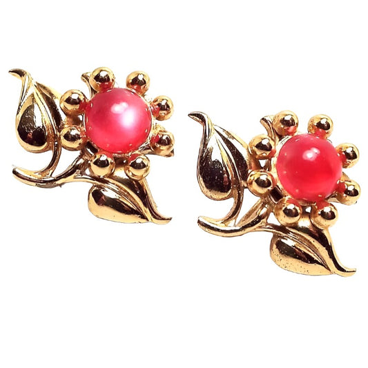 Front view of the Mid Century vintage vermeil floral earrings. The vermeil is gold plated over sterling for a rich gold color. They are shaped like flowers and have round domed glass cabs in a bright pink with a moonglow effect.