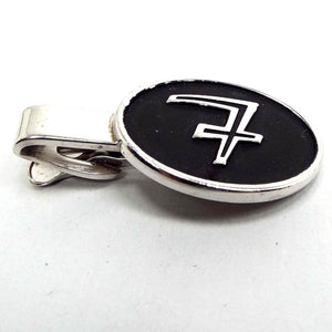 Front view of the 1950's Hickok vintage initial tie clip. It is silver tone in color with a large black oval on the end. There is a fancy letter T in the middle of the oval.