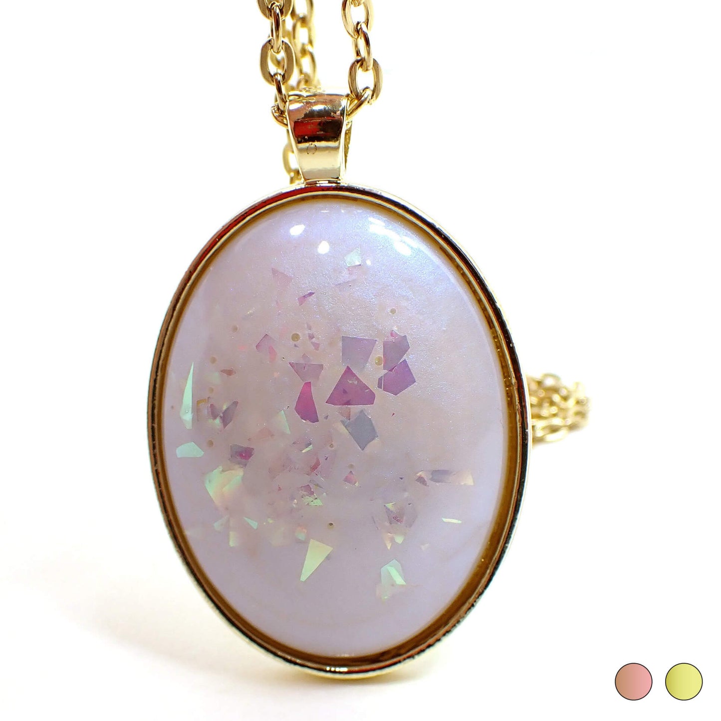Front view of the large handmade oval resin pendant necklace. The resin has an opal like color shift sheen of blue. There is AB pink chunky glitter embedded in the resin. The setting shown is gold plated color but there are two dots at the bottom right of the photo showing a choice of rose gold plated or gold plated.