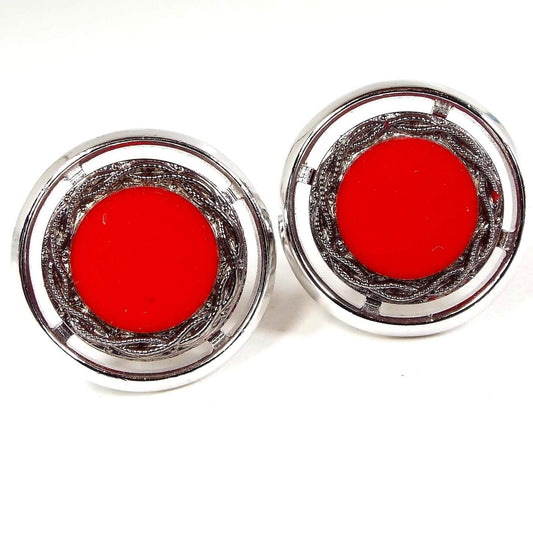 Front view of the Mid Century vintage Hickok cufflinks. They are round and silver tone in color. The middle has bright red glass cabs. There is a tiny chip in one towards the edge when viewed under magnification.