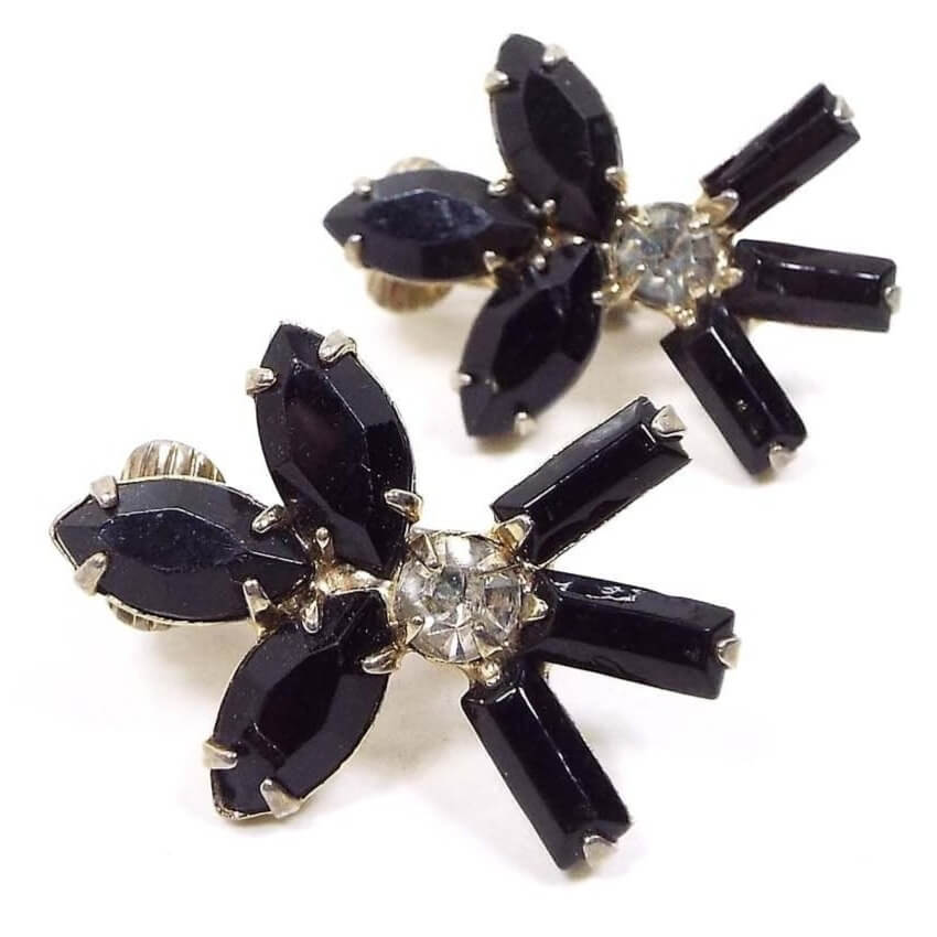Front view of the Mid Century vintage black and clear rhinestone clip on earrings. The top has three marquis shaped black rhinestones. There is a clear round rhinestone in the middle and three black baguette shaped rhinestones at the bottom.