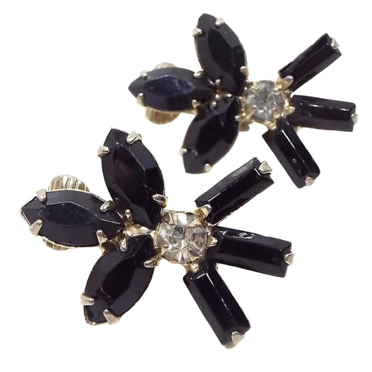Front view of the Mid Century vintage black and clear rhinestone clip on earrings. The top has three marquis shaped black rhinestones. There is a clear round rhinestone in the middle and three black baguette shaped rhinestones at the bottom.