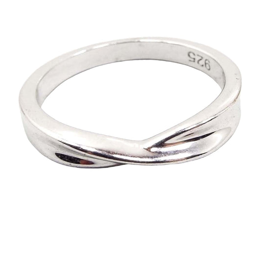 Angled front and top view of the retro vintage sterling silver twist band ring. The silver is nice and bright color. The top part of the ring has a pinched in area with a slight twist design, The marking 925 can be seen stamped on the inside of the band.