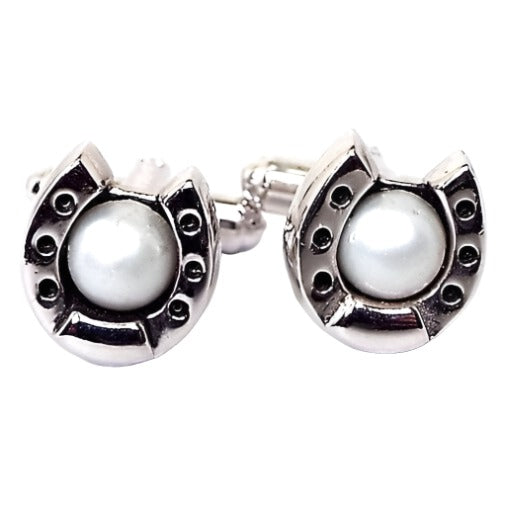 Front view of the Mid Century vintage Hickok cufflinks. They are silver tone in color and shaped like a horseshoe. There are white faux pearls in the middle.