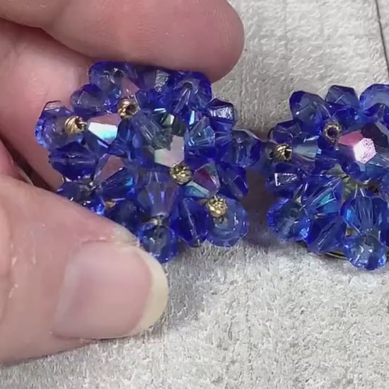 Video of the Mid Century vintage clip on earrings. They are cluster beaded with blue glass crystal beads. The video is showing how the beads sparkle.
