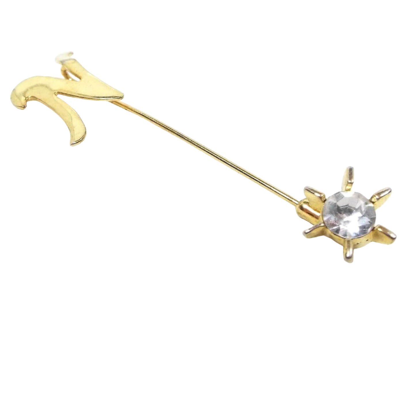Front view of the Mid Century vintage rhinestone initial stick pin. The metal is gold tone in color. There is a curvy flat letter N at the top and a rhinestone starburst clutch at the bottom.