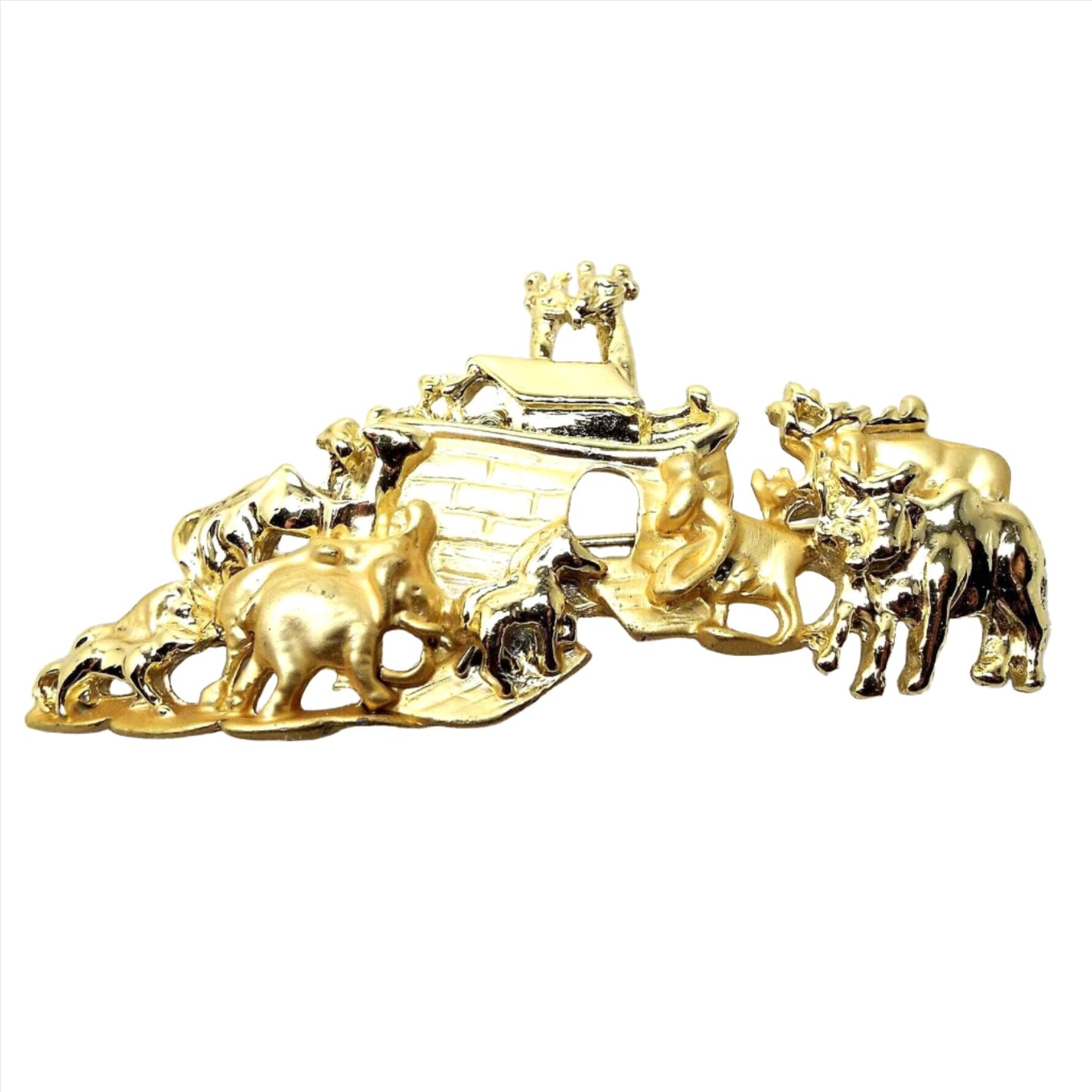 Front view of the retro vintage AJC Noah's Ark brooch pin. It is matte and shiny gold in color. The ark has an open doorway and is surrounded by a variety of animals.