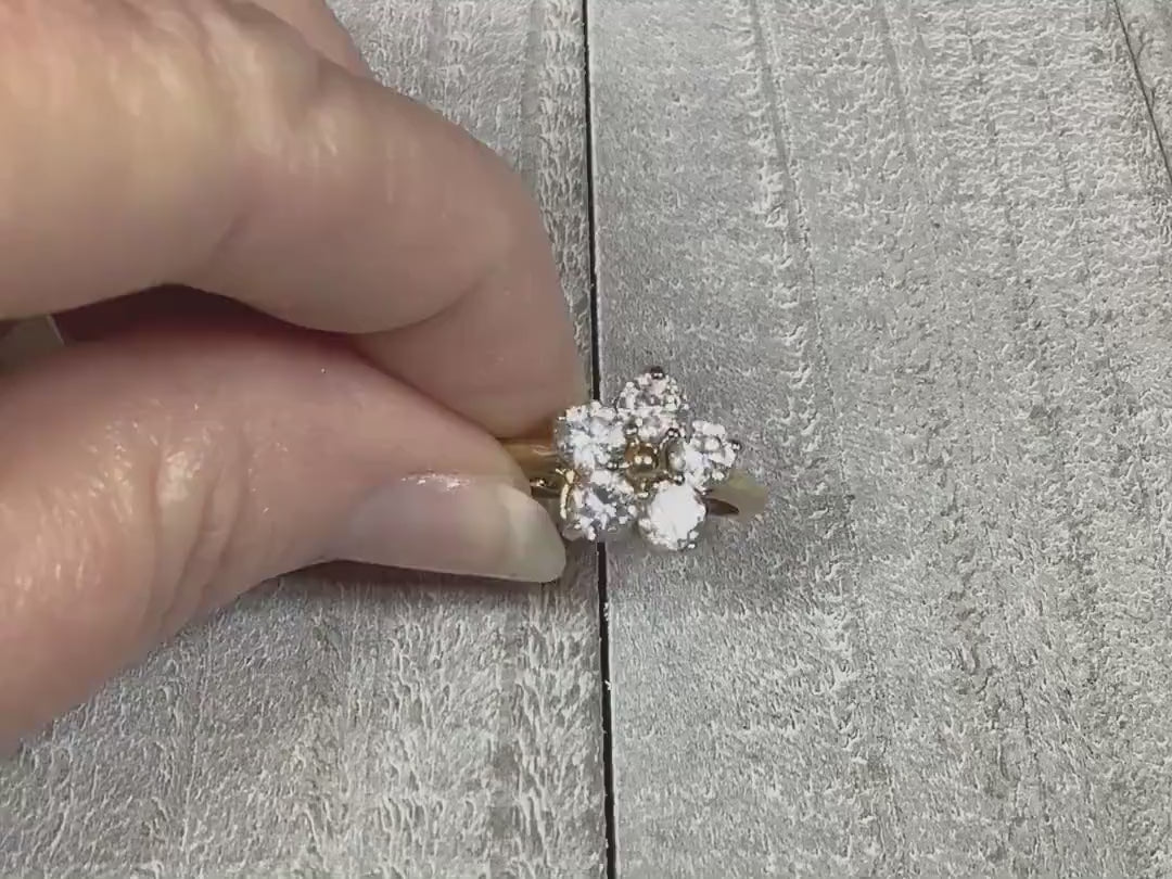 Video of the Edco retro vintage rhinestone cocktial ring. The metal is gold tone in color.  There are five round clear rhinestones at the top forming a flower shape. The video shows how the rhinestones sparkle.