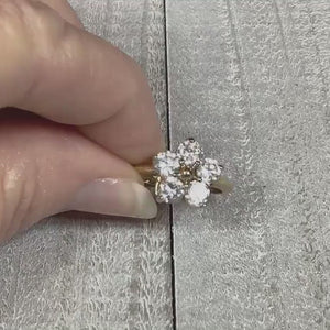 Video of the Edco retro vintage rhinestone cocktial ring. The metal is gold tone in color.  There are five round clear rhinestones at the top forming a flower shape. The video shows how the rhinestones sparkle.