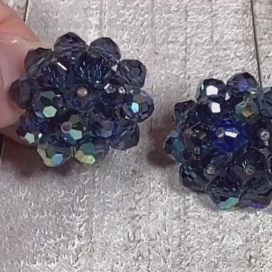 Video of the Mid Century vintage Laguna clip on earrings. They are beaded with AB blue crystal glass beads in a cluster style shape. The video is showing how the beads sparkle.