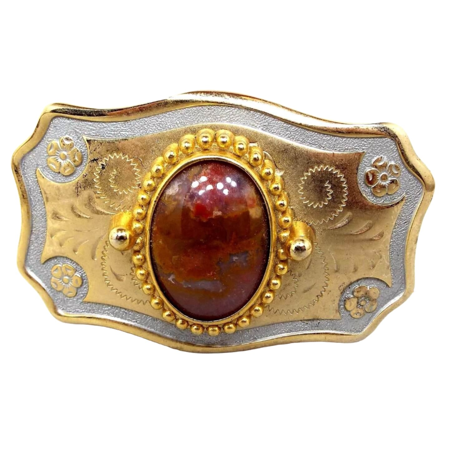 Front view of the retro vintage agate gemstone belt buckle. The buckle is mostly gold tone in color with silver tone around the edge. There are flowers at the corners and an etched design in the middle area. In the very middle is an oval agate cab with shades of brown and orange.
