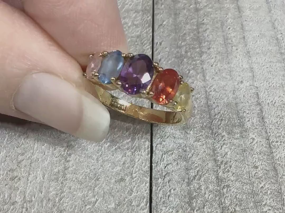 Video showing the sparkle of the multi color rainbow rhinestone ring. There are pink, blue, purple, orange, and yellow oval rhinestones at the top of the ring.