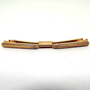 Front view of the Mid Century vintage curved collar clip. It is darkened gold tone in color and has some light scuff scratching on the right hand side.