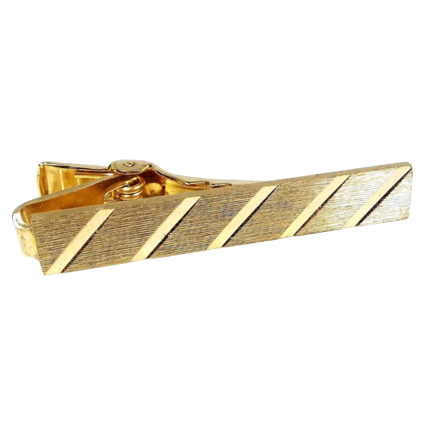 Front view of the Mid Century vintage diagonal striped tie clip. It is gold tone in color with a brushed matte front. There are shiny diagonal lines cut along the front.