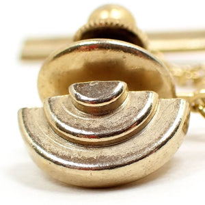 Enlarged front view of the Mid Century vintage tie tack. It is gold tone plated in color and has a stacked curve design. 