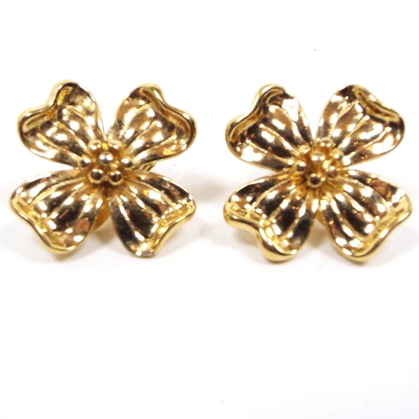Front view of the retro vintage dogwood flower clip on earrings by Monet. They are gold tone in color and flower shaped.
