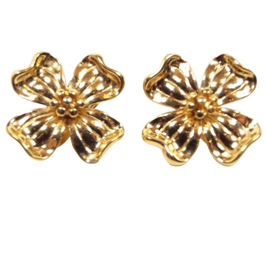 Front view of the retro vintage dogwood flower clip on earrings by Monet. They are gold tone in color and flower shaped.