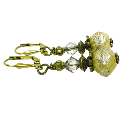 Side view of the multi color Czech glass beaded earrings. The metal is antiqued brass in color. There are very light smoky gray faceted glass crystal beads at the top. The bottom Czech glass beads are a faceted rondelle type shape with shades of yellow, green, and hints of brown in the recesses.