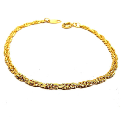 Angled view of the retro vintage Trifari chain bracelet. It is gold tone in color with a twisted rope chain design. There is a spring ring clasp at the end.